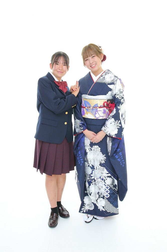 振袖前撮り撮影会で紺地の振袖を着た女性と高校の制服を着た妹と並んでいる